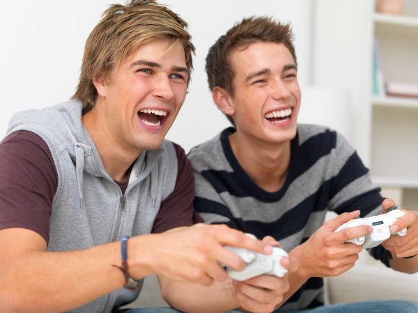 Closeup of two friends playing video game