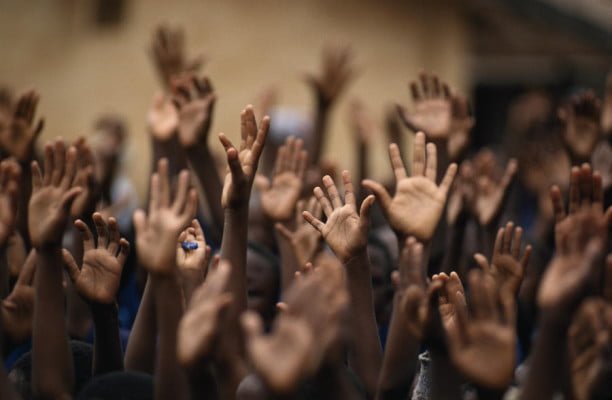 school-children-raise-their-hands-lynn-johnson