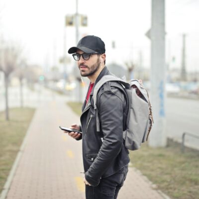 Mężczyzna w czapce z daszkiem ze smartfonem w dłoni.