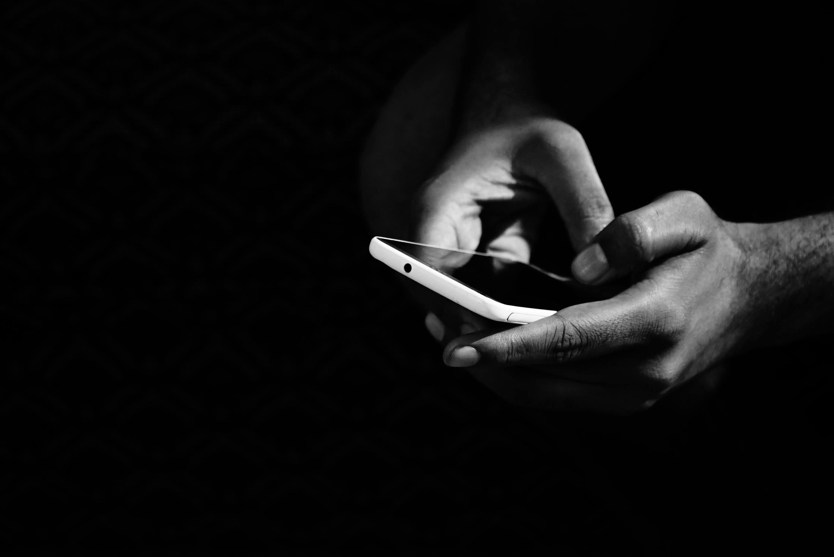 Smartfon w rękach, ciemna strona technologii AI