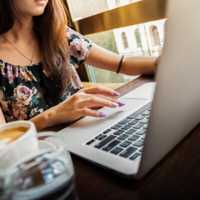 kobieta siedząca przed laptopem apple macbook