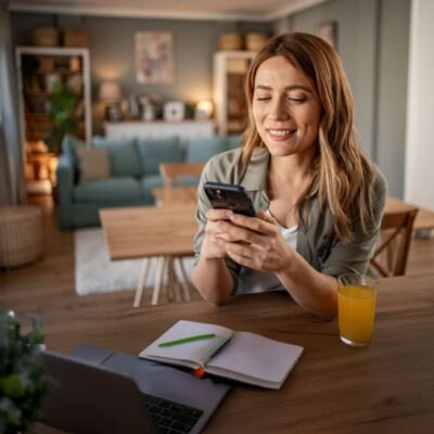 Płatności powtarzalne Blik w Allianz, kobieta z telefonem, smartfonem, zakupy, notatnik