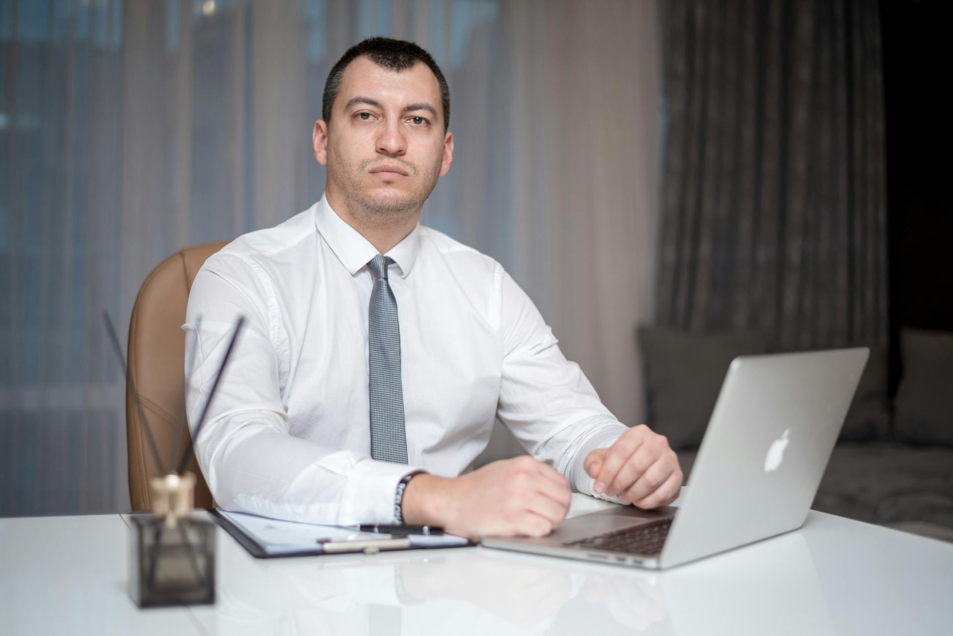 mężczyzna siedzący przed laptopem firmy Apple