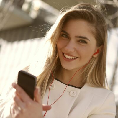 Kobieta, zadowolona, uśmiechnięta, rozmowa przez smartfon, telefon, słuchawki