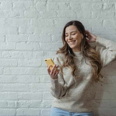 Kobieta, zadowolona, szczęśliwa, smartfon, słuchawki