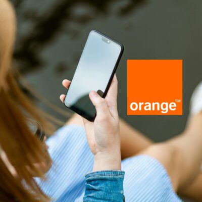 dziewczyna trzymająca smartfon w ręce; obok logo orange