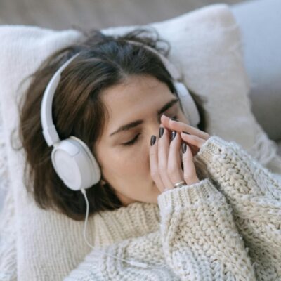 Kobieta, słuchawki, zmęczona, ból głowy