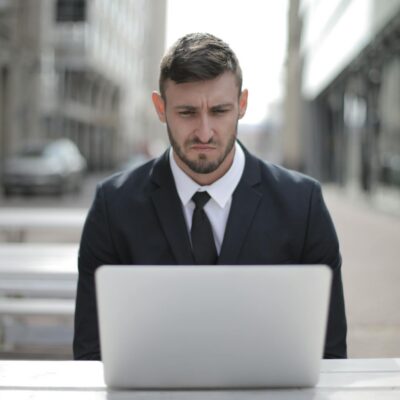smutny mężczyzna siedzący przed laptopem