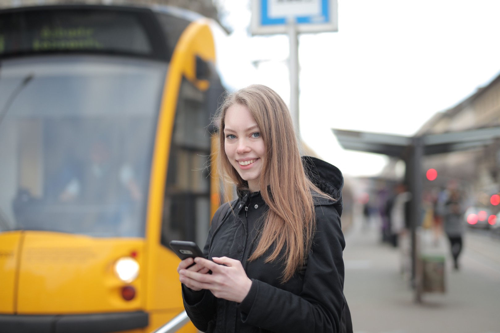 kobieta, zadowolona, smartfon, telefon, przystanek, autobus