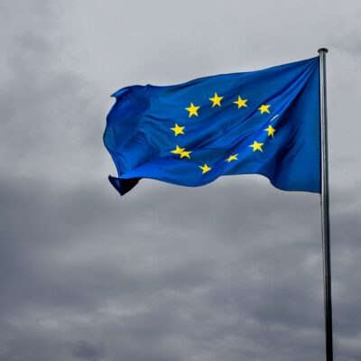 flaga unii europejskiej na tle zachmurzonego ciemnego nieba