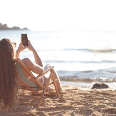 kobieta dziewczyna na plaży z telefonem smartfonem w ręce